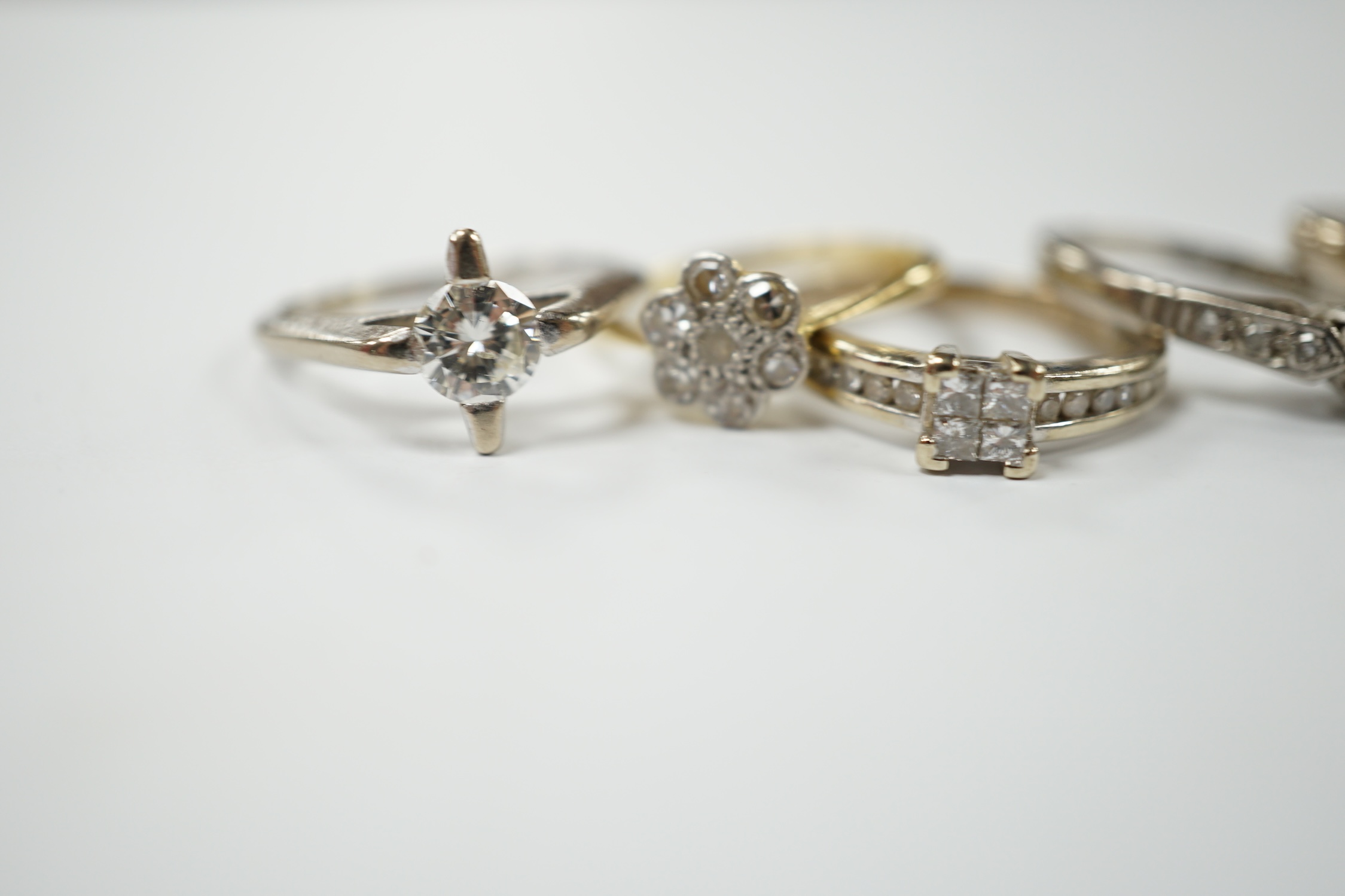 Four assorted 18ct, plat and diamond rings, including two solitaires and a flower head cluster, together with a modern 9ct and diamond cluster ring. Condition - fair